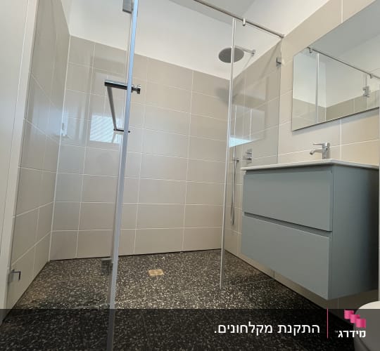מקלחון זכוכית הזזה פינתי מותקן בחדר רחצה מעוצב